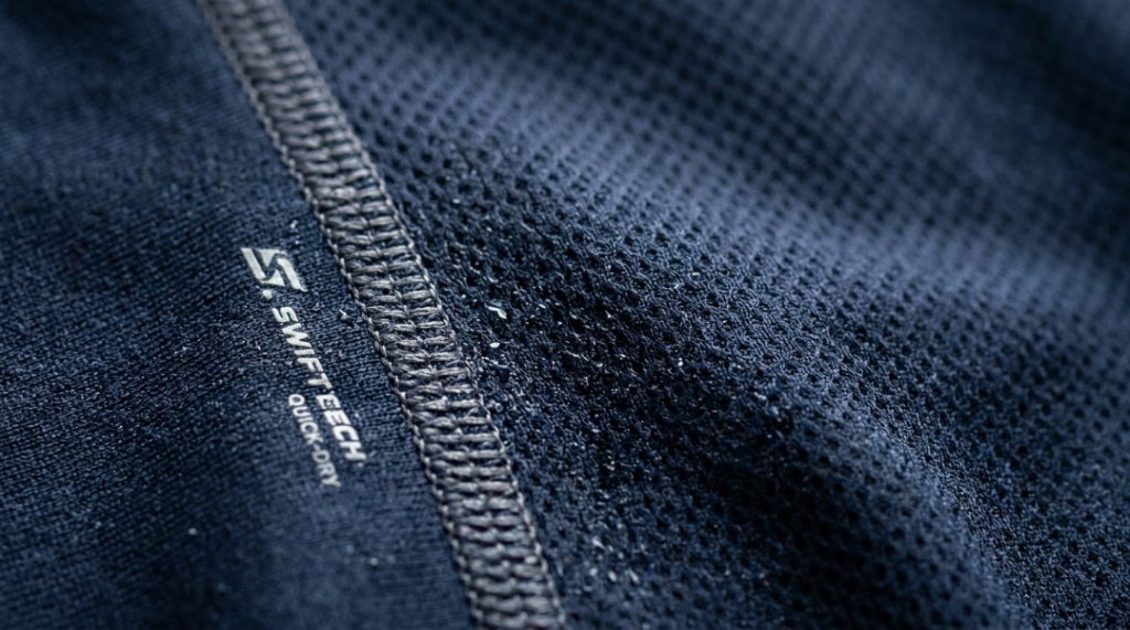 Close-up of moisture-wicking gym shirt fabric showing flat-lock seams and quick-dry texture designed for athletic performance