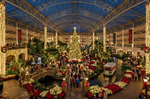 Families walking through glowing ice sculptures inside the ICE! attraction at Gaylord Opryland Resort during the 2026 Christmas season