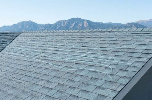 High winds lifting asphalt shingles on a Denver roof