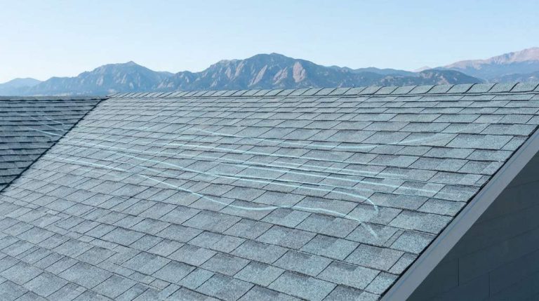 High winds lifting asphalt shingles on a Denver roof